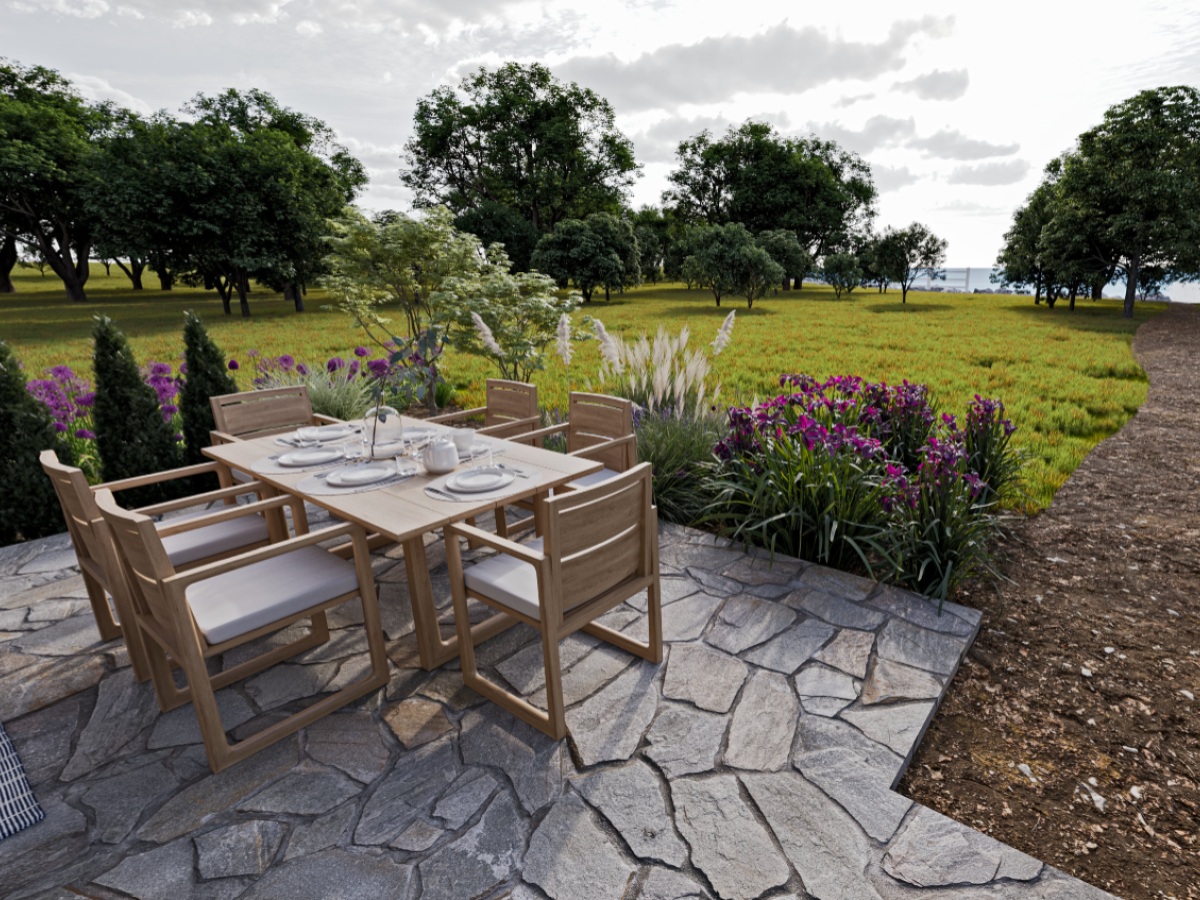 A patio with a wooden dining set, surrounded by lush greenery, colorful flowers, and trees under a partly cloudy sky, is beautifully featured.